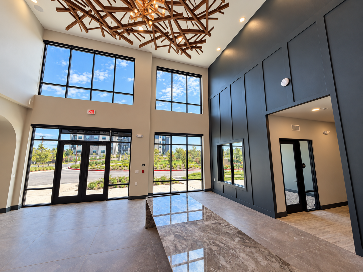 Double-height multifamily lobby with storefront glazing and glass entrances