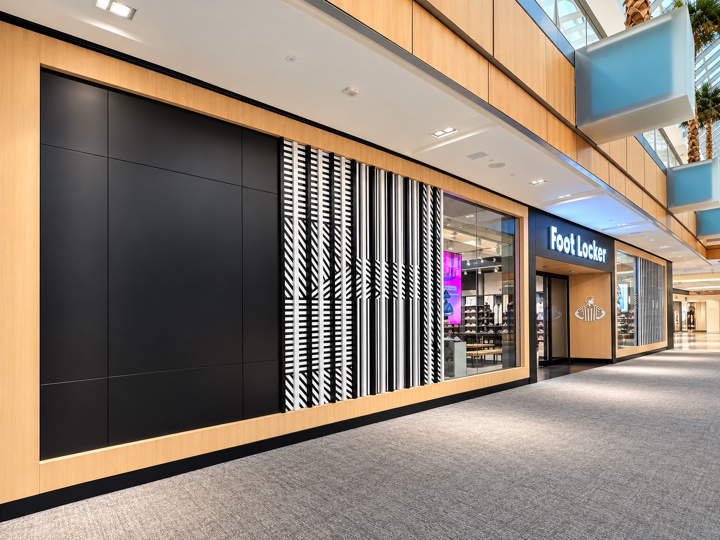 Angled view of Foot Locker storefront glazing and black metal panels