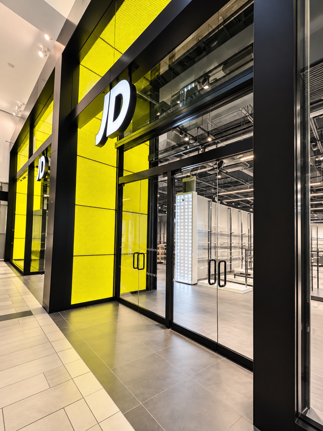 JD mall entrance with heavy glass doors and black metal detailing