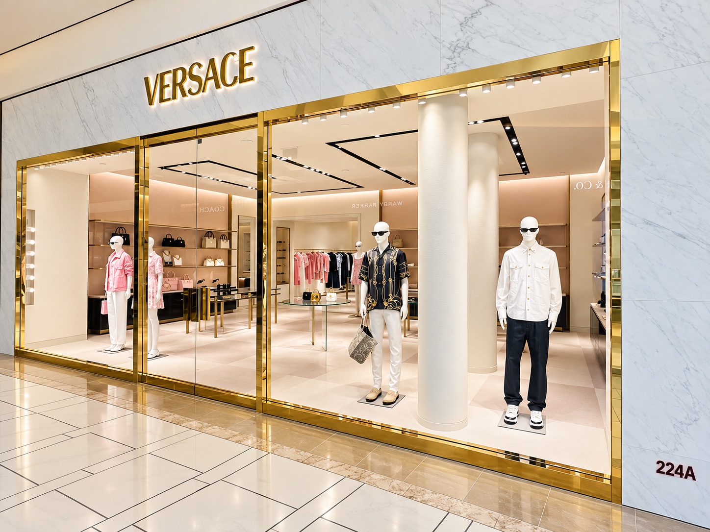 Angled view of a Versace storefront with heavy glass and gold-toned brake metal